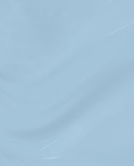 Soft denim-blue Baggy Jean Baby nail lacquer swatch gliding in glossy waves on a clean background, showcasing a creamy, opaque finish perfect for fall nail colors.