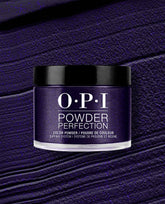 OPI Powder Perfection Don't Over Ink It dipping powder jar displays a deep shimmering purple shade against a textured powder swatch, a bold choice for fall nail colors.