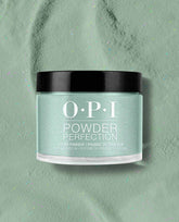OPI Powder Perfection Feelin’ Capricorn-y dipping powder jar showcases a pastel mint green nail polish shade with fine shimmer, set on a matching powder surface with subtle confetti specks—fresh pick for spring nail colors from OPI.