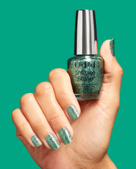OPI Hang the Mintsell Infinite Shine green nail polish shimmering on manicured nails as a hand holds the matching bottle against a teal backdrop, highlighting full-coverage glitter ideal for spring nail colors.