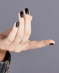 Hand displays glossy near-black purple nails painted with OPI Lincoln Park After Dark nail lacquer, a dramatic choice for fall nail colors, against a gray background.