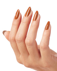 Hand with long oval nails painted in My Italian is a Little Rusty, a glossy warm terracotta OPI nail polish, shown against a clean white background to highlight the rich fall nail lacquer shade and smooth, even coverage.