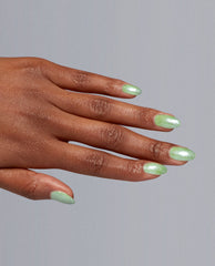 Manicured hand showcases Taurus-t Me Nail Lacquer by OPI—an iridescent mint green nail polish on almond-shaped nails—highlighting fresh spring nail colors against a clean gray backdrop.