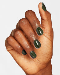 Hand with short, neatly manicured nails painted in Things I’ve Seen in Aber-green, a deep glossy forest shade of OPI nail polish nail lacquer, shown against a clean white background to highlight the rich green color and smooth finish.