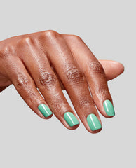 Glossy mint green nails showcase OPI No Further Delays RapiDry™, a quick-dry green nail polish, as the hand fans against a light gray background, spotlighting fresh spring nail colors with a smooth, chip-free finish.