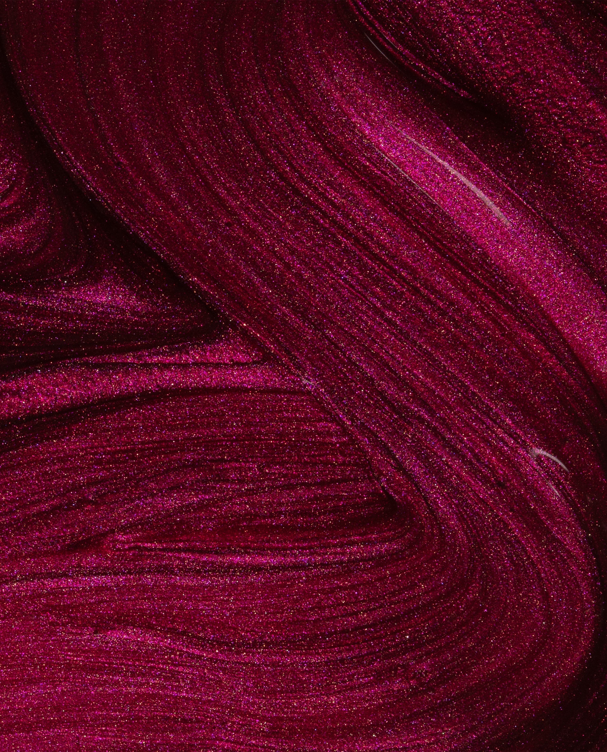 Big Sagittarius Energy nail lacquer swirled in close-up, showing deep magenta OPI nail polish with fine glitter shimmer and smooth, glossy texture across the frame.