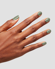Short, rounded nails painted olive-sage with Cargo All Out nail lacquer, hand splayed to showcase a glossy, even coat against a clean light gray background, highlighting an earthy, on-trend choice for fall nail colors.