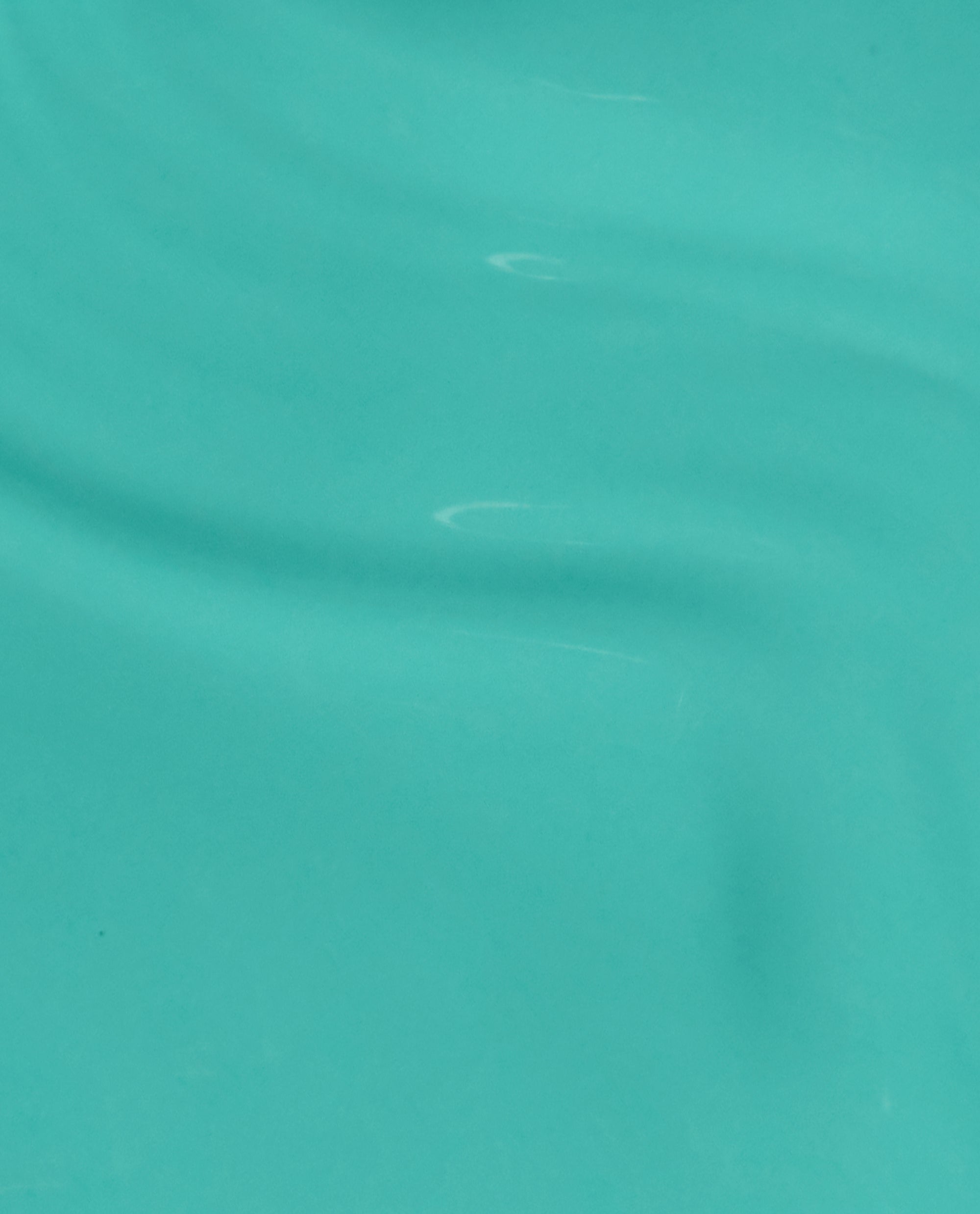OPI I’m Yacht Leaving nail lacquer swatch flowing in glossy brush strokes, showcasing a bright aqua-teal green nail polish ideal for spring nail colors on a smooth surface with subtle ripples and shine.