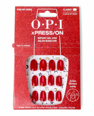 Kiss My Aries xPRESS/ON Effects red press-on nails displayed in glittery red OPI nail polish–themed packaging, featuring 30 glossy red nails with gold zodiac symbols and text promising instant gel-like salon manicure and zodiac stickers inside.