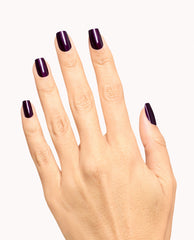 Hand modeling glossy deep eggplant purple nails using Lincoln Park at Midnight dipping powder, an OPI-inspired shade for dramatic fall nail colors on a clean white background.