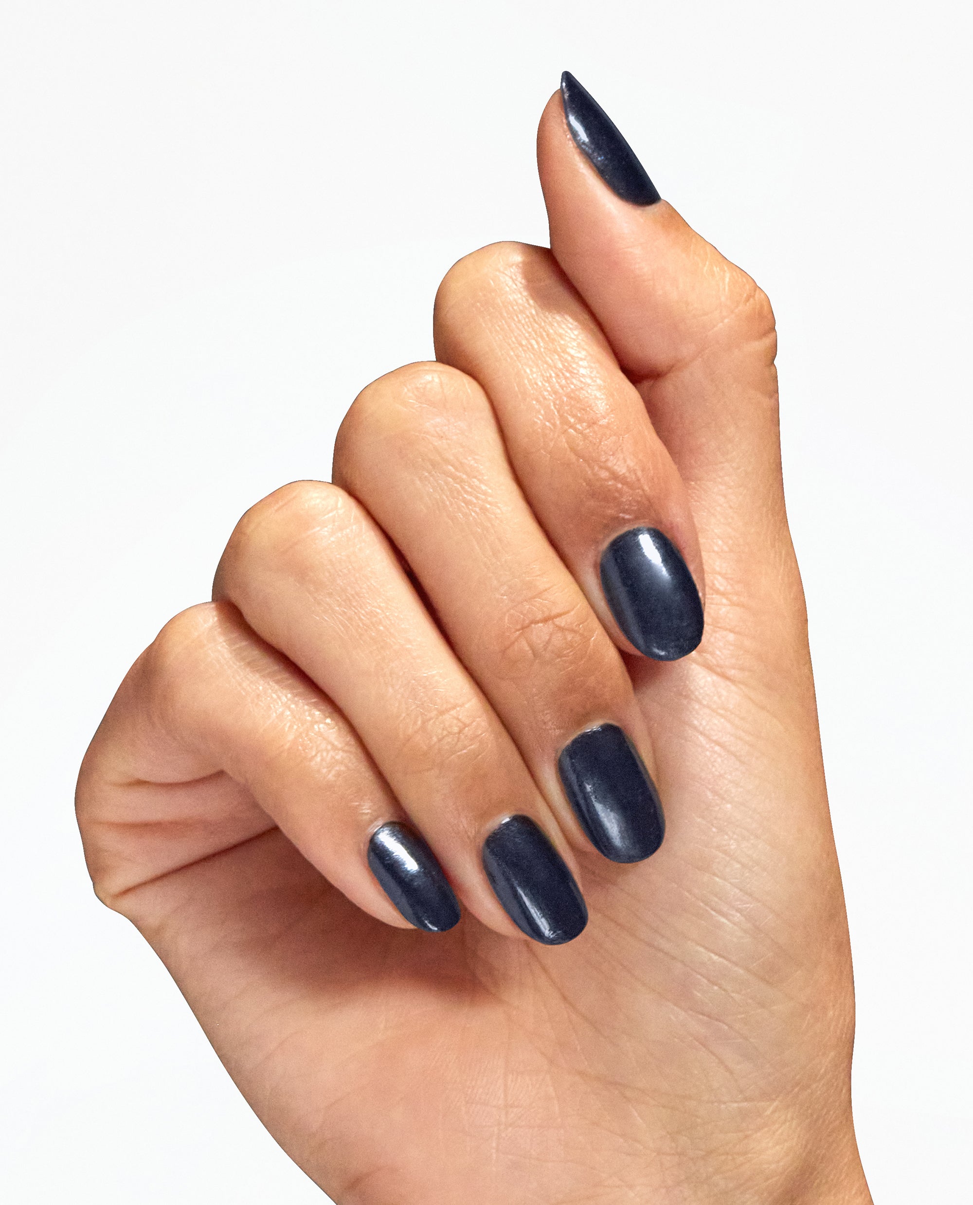 Hand with neatly manicured oval nails showcases Midnight Mantra nail lacquer, a deep midnight blue OPI nail polish with a subtle shimmer, against a clean white background.