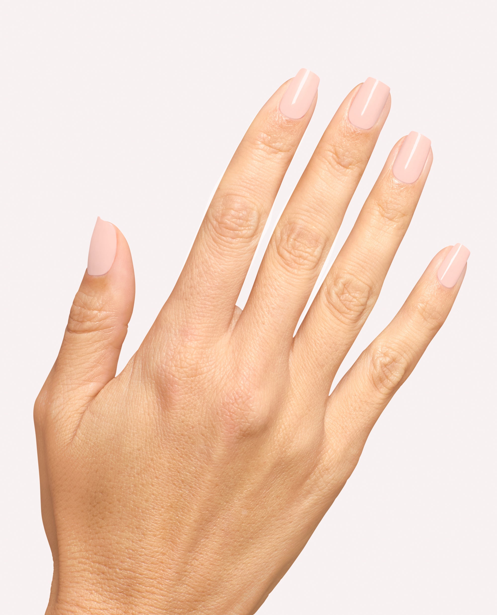 Hand displays glossy pale pastel pink square nails with Mod About You Pastel dipping powder, a soft OPI shade for fall nail colors, against a clean light background.