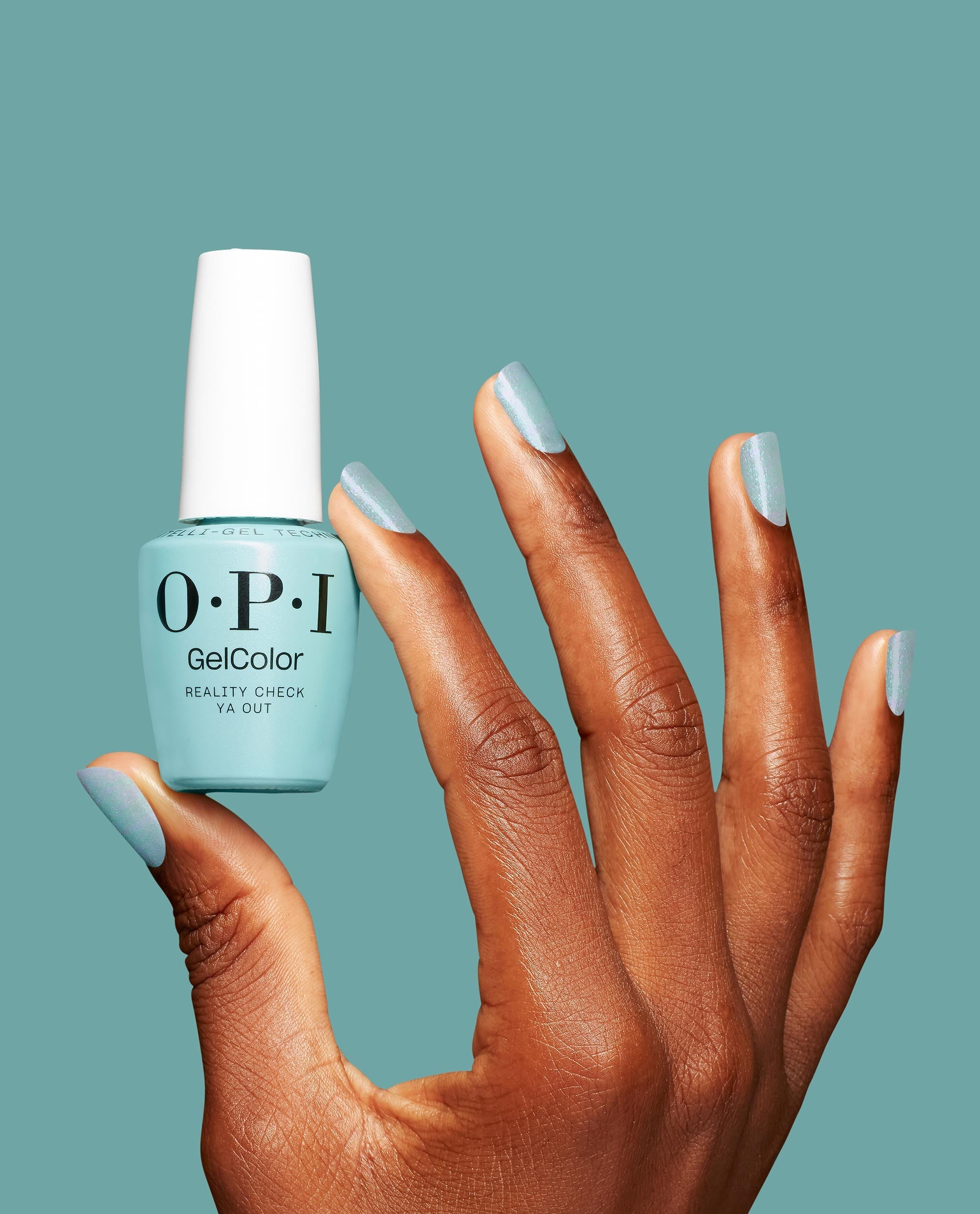 OPI GelColor Reality Check Ya Out gel nail polish bottle held between manicured fingers, nails painted the same mint green shade, showcasing green nail polish ideal for spring nail colors by OPI against a matching teal background.