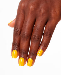 Hand displays glossy OPI Sun, Sea, and Sand in My Pants Nail Lacquer, a bright marigold yellow polish on short square nails, showcasing spring nail colors and spring nail trends against a clean white background.