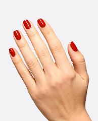 Hand modeling glossy deep red Vodka & Caviar gel nail polish, an OPI shade for classic fall nail colors, on short rounded nails against a light gray background.